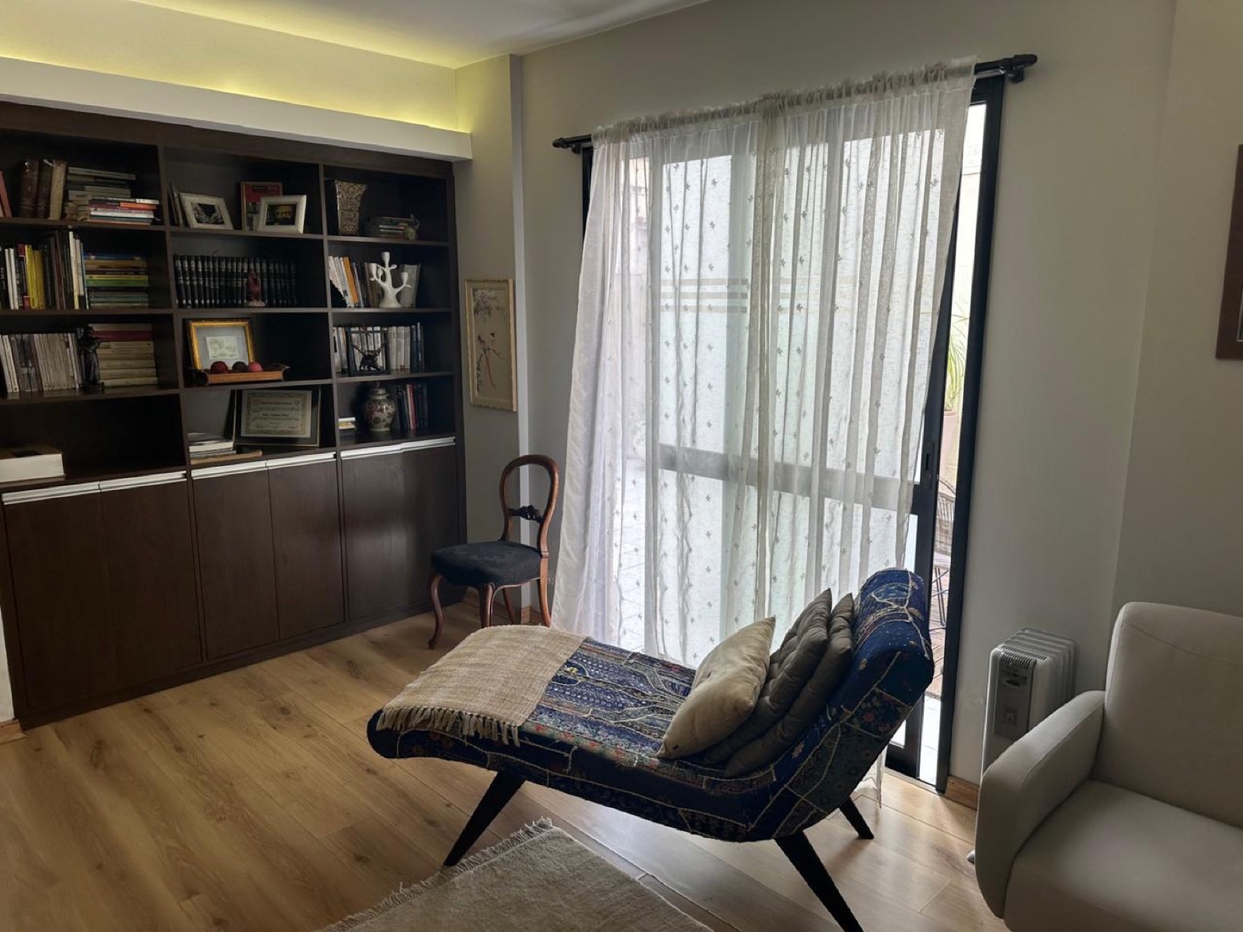 Sala de atendimento com livraria, divã e luz natural